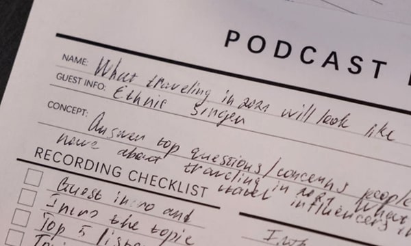 Close-up view of podcast recording checklist sheet filled with scribbles and markings